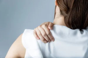 肩こりを気にして肩に手を当てている女性