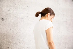 猫背の女性の斜め後ろ姿